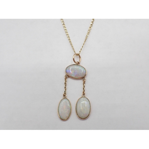 114 - An Opal Négligée Necklace spectacle-set oval stone suspending two drops each set further stone on fi... 