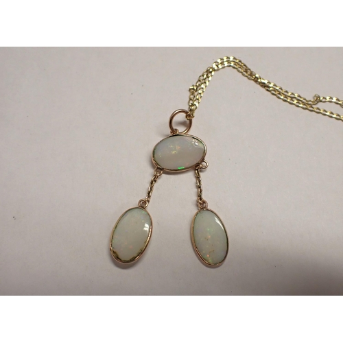 114 - An Opal Négligée Necklace spectacle-set oval stone suspending two drops each set further stone on fi... 