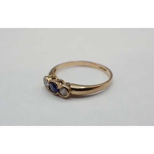 175 - A Sapphire and Diamond three stone Ring rubover-set round sapphire between two brilliant-cut diamond... 