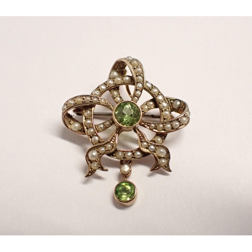 192 - A Peridot and Seed Pearl Pendant/Brooch millegrain-set round peridot within openwork ribbon effect p... 