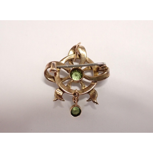 192 - A Peridot and Seed Pearl Pendant/Brooch millegrain-set round peridot within openwork ribbon effect p... 