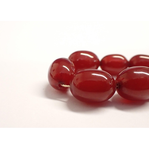 193 - A string of graduated Cherry Amber type Beads, approx 65cms long,  approx 32gms