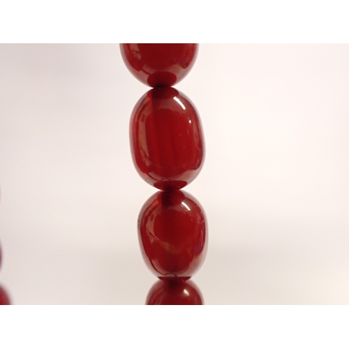 193 - A string of graduated Cherry Amber type Beads, approx 65cms long,  approx 32gms