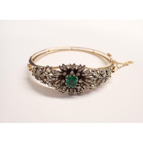 207 - An Emerald, Seed Pearl and Diamond hinged Bangle the front with flower effect claw-set step-cut emer... 