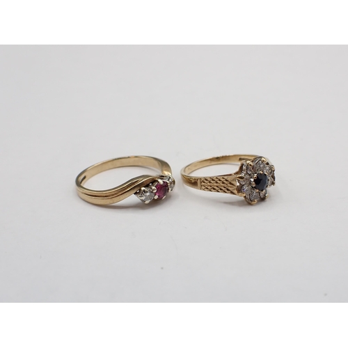 229 - A Ruby and Diamond three stone crossover Ring claw-set round ruby between two brilliant-cut diamonds... 