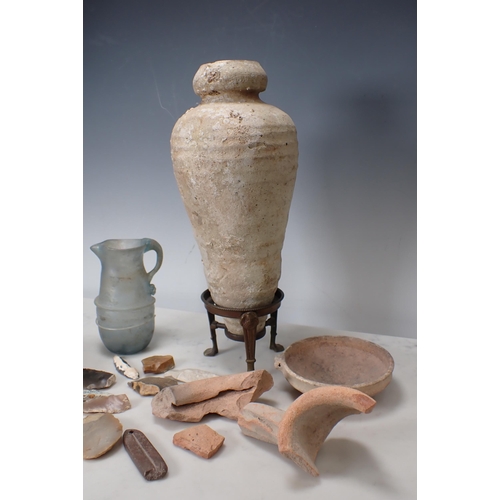 316 - A Roman Amphora on a metal stand, a Roman glass Jug and a collection of Roman/Egyptian fragments of ... 