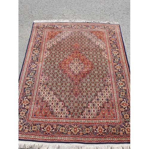 381 - A Persian woollen Rug with graduated lozenges infilled with stylised floral decoration on red, blue ... 