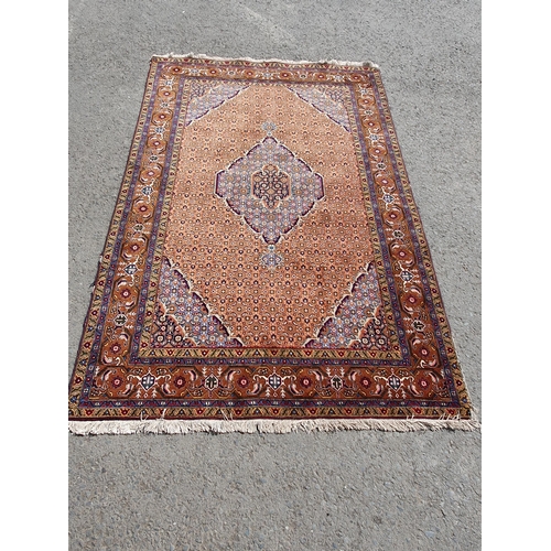 382 - A Persian woollen Rug with pale blue central lozenge on peach ground decorated with stylised flowers... 