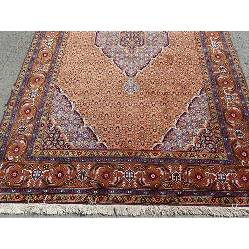 382 - A Persian woollen Rug with pale blue central lozenge on peach ground decorated with stylised flowers... 