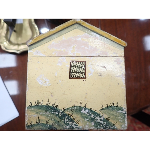 450 - A Folk Art Work Box in the form of a cottage with painted design, the pitched roof hinged cover cont... 