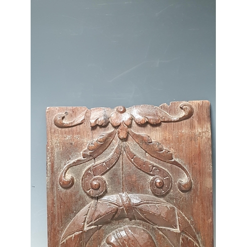 478 - A Tudor period carved oak Panel with head in a circular wreath border with scroll carved decoration
... 