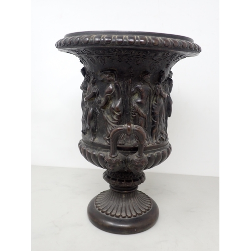 484 - A bronze two-handled Classical Urn with frieze of figures, gadroon base with mask handles, 8½in