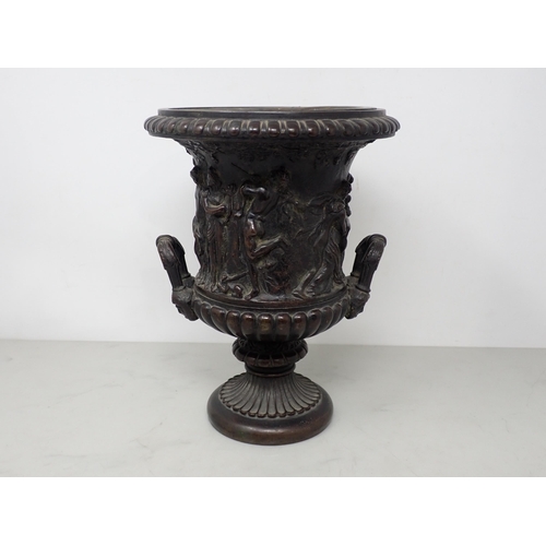 484 - A bronze two-handled Classical Urn with frieze of figures, gadroon base with mask handles, 8½in