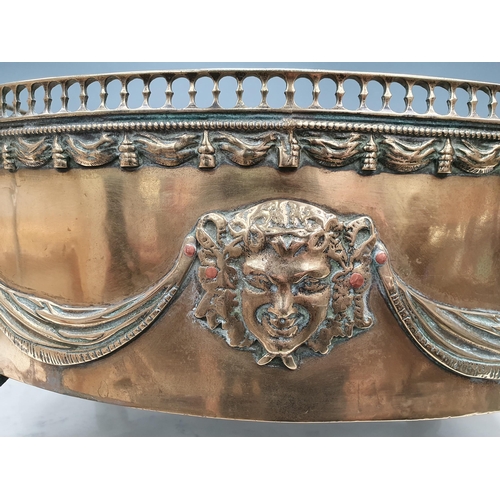 490 - A Georgian brass oval two handled Jardiniere with pierced spindle gallery, mask and swag design and ... 