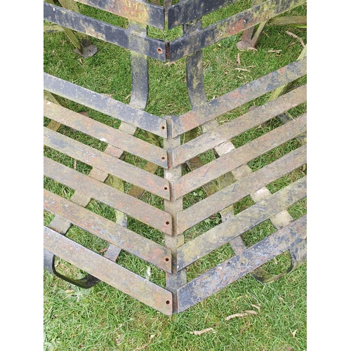 513 - A black painted wrought iron Tree Seat in two sections to surround a tree, with horizontal slats on ... 