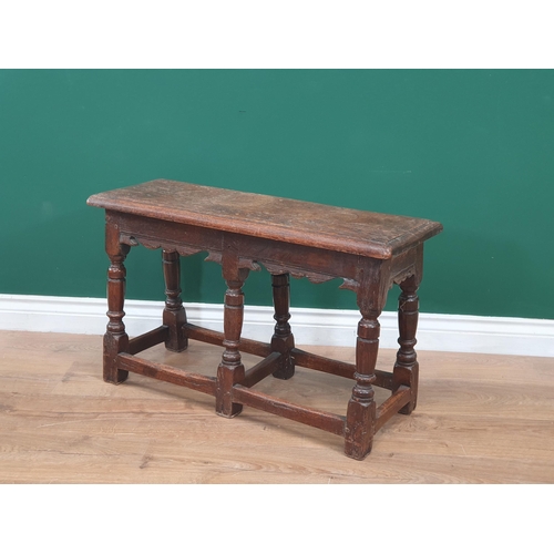 551 - An antique oak Joined Stool in 17th Century style with moulded top above a shaped frieze and raised ... 