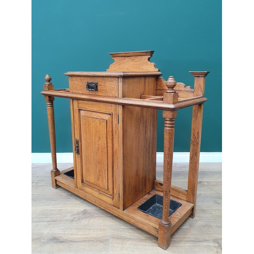 556 - An Arts & Crafts light oak Hallstand fitted drawer above a cupboard door flanked by stick/umbrella s... 