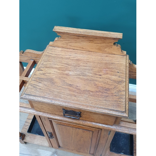 556 - An Arts & Crafts light oak Hallstand fitted drawer above a cupboard door flanked by stick/umbrella s... 