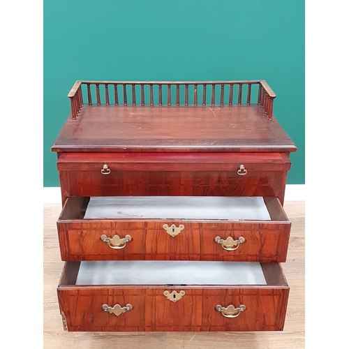 560 - An antique walnut Chest with spindle gallery, brushing slide above two feather banded drawers and tw... 