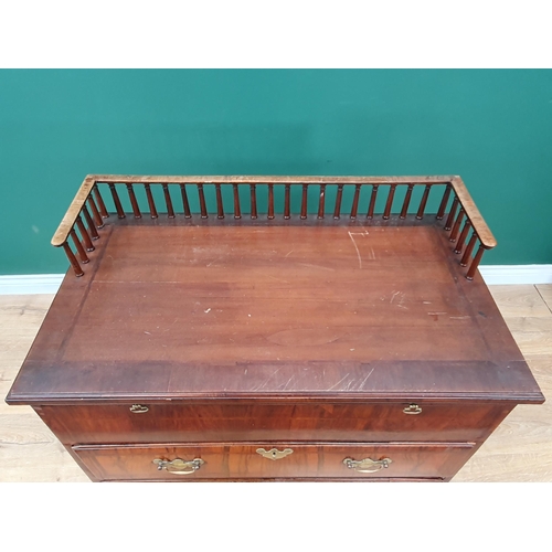 560 - An antique walnut Chest with spindle gallery, brushing slide above two feather banded drawers and tw... 