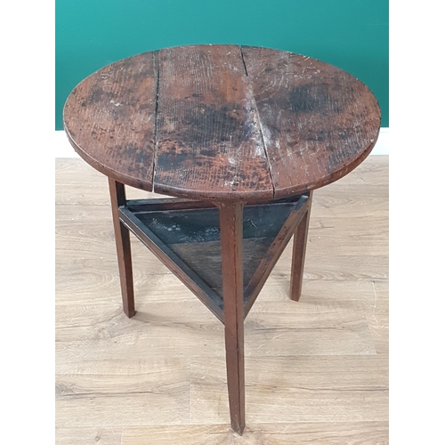 565 - An antique oak Cricket Table with circular top, triangular under tier on three legs, 2ft diam