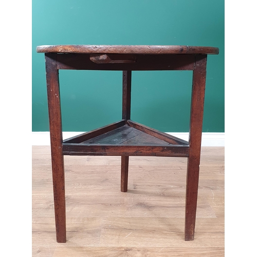 565 - An antique oak Cricket Table with circular top, triangular under tier on three legs, 2ft diam