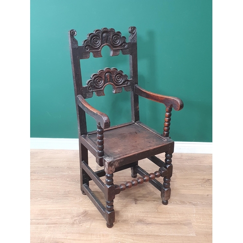 567 - A Derbyshire oak Elbow Chair with solid seat on turned and squared front supports and bobbin turned ... 