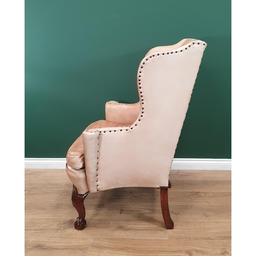 568 - A George III style walnut Wingback Armchair in pale tan leather with outswept arms, raised on carved... 