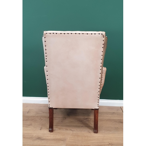 568 - A George III style walnut Wingback Armchair in pale tan leather with outswept arms, raised on carved... 