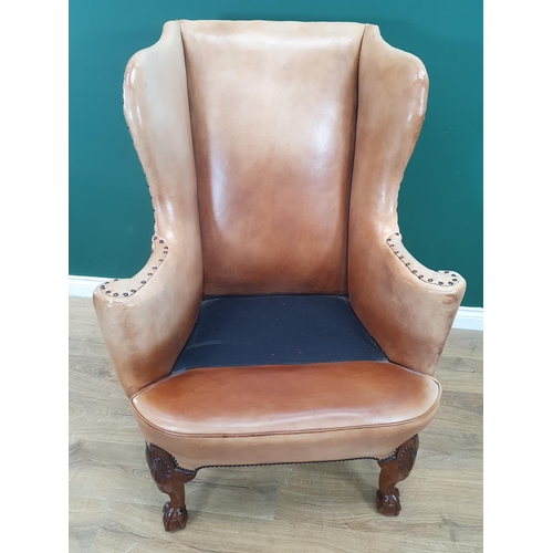 568 - A George III style walnut Wingback Armchair in pale tan leather with outswept arms, raised on carved... 