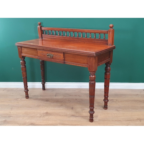 574 - An aesthetic walnut Side Table with raised gallery to the back and fitted a frieze drawer on turned ... 