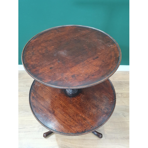 577 - A Georgian mahogany circular graduated two tier Dumb Waiter with dished tiers on baluster turned col... 