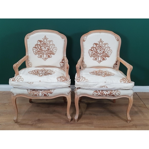 593 - A pair of French beechwood framed Elbow Chairs with cream silk upholstery and rose and gilt foliate ... 