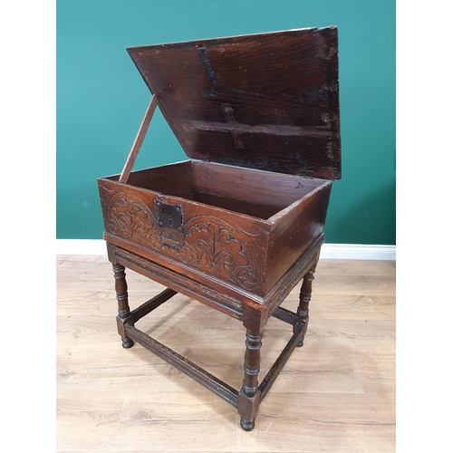 605 - An 18th Century oak Blanket Box on Stand with moulded hinged top, carved front, the stand with turne... 