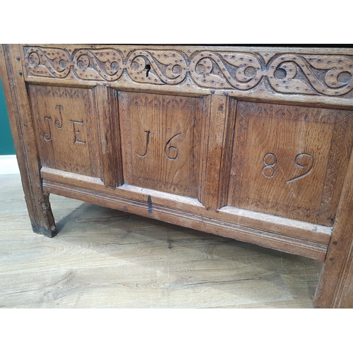 631 - A 17th Century oak Coffer with hinged top above a carved frieze and three panelled front dated 1689,... 