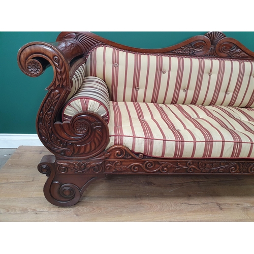 632 - A Regency carved mahogany Settee, the shaped back and rolled arms above a cushion seat raised on scr... 