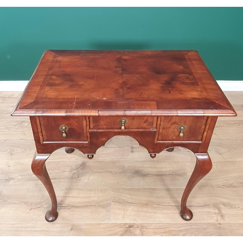 636 - A Georgian walnut Lowboy with quarter veneered, feather banded top above three drawers surrounding a... 