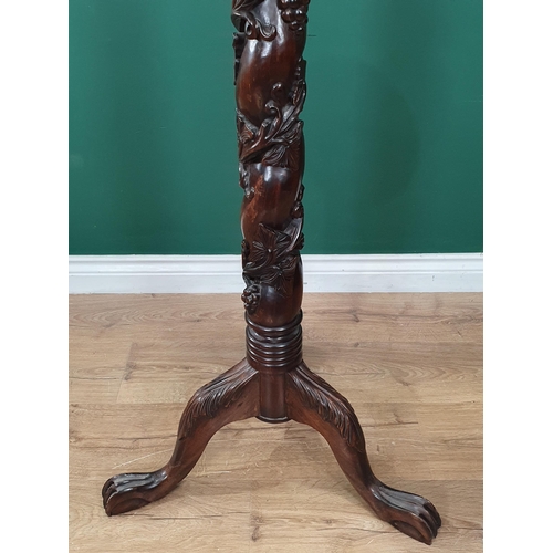 652 - A mahogany Torchiere Stand with trailing fruiting vine carving to column, mounted upon tripod base w... 