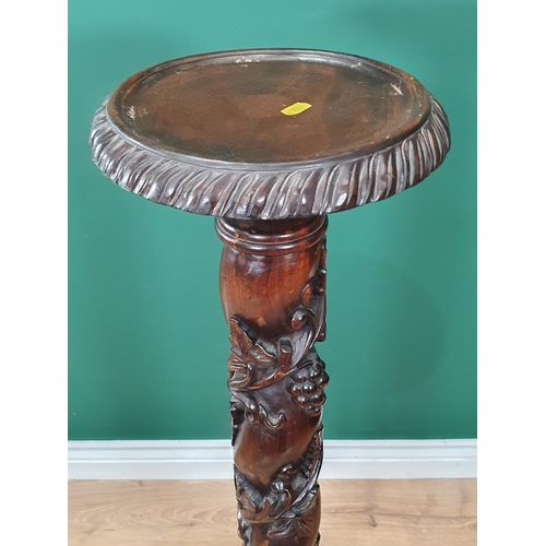 652 - A mahogany Torchiere Stand with trailing fruiting vine carving to column, mounted upon tripod base w... 