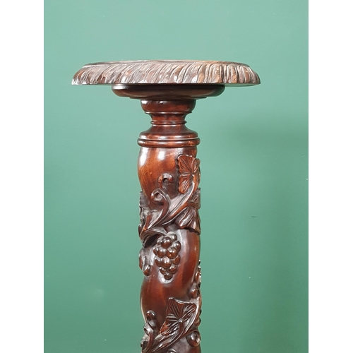 652 - A mahogany Torchiere Stand with trailing fruiting vine carving to column, mounted upon tripod base w... 