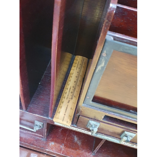 667 - A 1920's mahogany Desk with hinged top and front, opening to reveal a fitted interior of pigeon hole... 