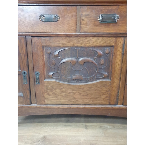 668 - An Art Nouveau oak Mirror-back Dresser with a pair of doors inset with stylised floral panels flanke... 