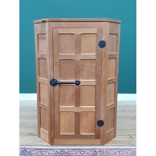 679 - A Mouseman Thompson oak hanging Corner Cupboard with 8 panel door