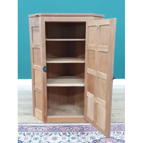 679 - A Mouseman Thompson oak hanging Corner Cupboard with 8 panel door