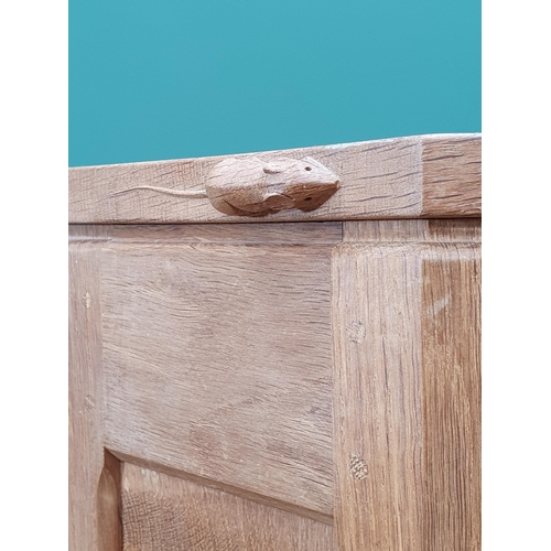 679 - A Mouseman Thompson oak hanging Corner Cupboard with 8 panel door