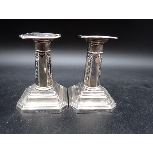 101 - A pair of dwarf silver Candlesticks with ribbon and paterae design on chamfered square bases, Sheffi... 