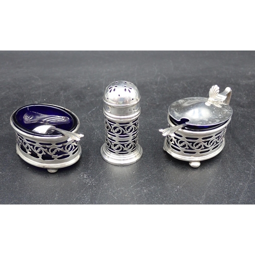 105 - A George V silver three piece Condiment Set with blue glass liners, and two Spoons, Birmingham 1919/... 