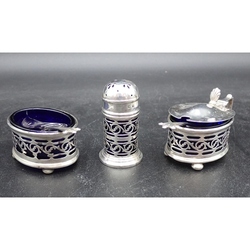 105 - A George V silver three piece Condiment Set with blue glass liners, and two Spoons, Birmingham 1919/... 