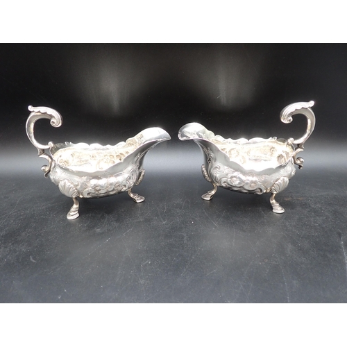 113 - A pair of George III large silver Sauce Boats with later floral embossing, leafage scroll handles on... 