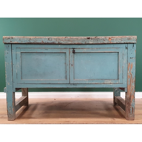 13 - A blue painted Pine Workbench with pair of panelled cupboard doors, 2ft 10